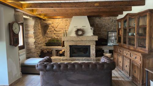 a living room with a stone fireplace and a couch at Finca San Román in Viascón
