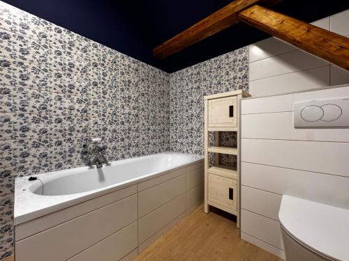 a bathroom with a tub and a sink at Apartmán U Medvěda in Vejprty
