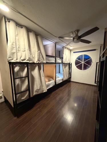 a room with bunk beds and a ceiling fan at Hostal Vibes in Oaxaca City