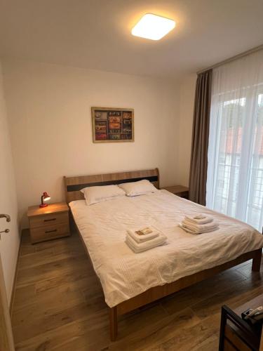 a bedroom with a bed with two towels on it at Apartman Simikic in Lopare