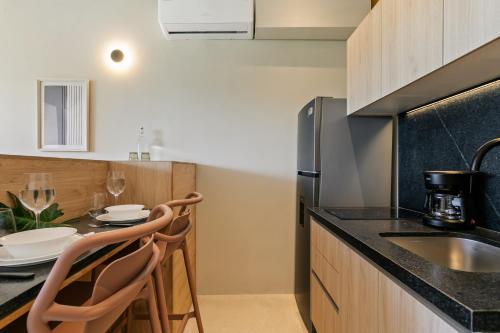 a kitchen with a sink and a table with chairs at Donceles Plaza in Cancún