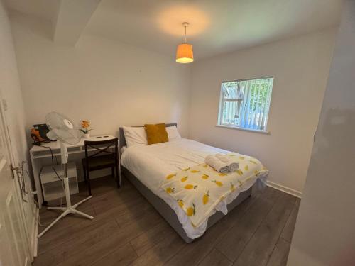 a bedroom with a bed and a desk and a window at London Heathrow Hayes Escape in South Ruislip Station