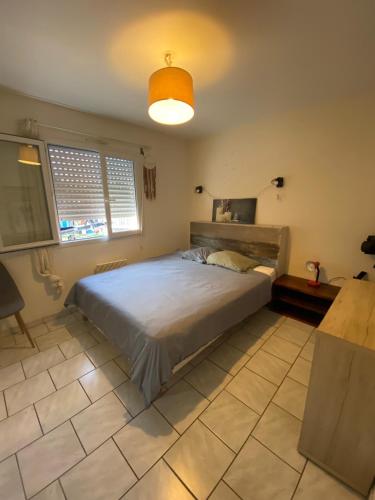 a bedroom with a large bed and a light at Villa Cazaux in La Teste-de-Buch
