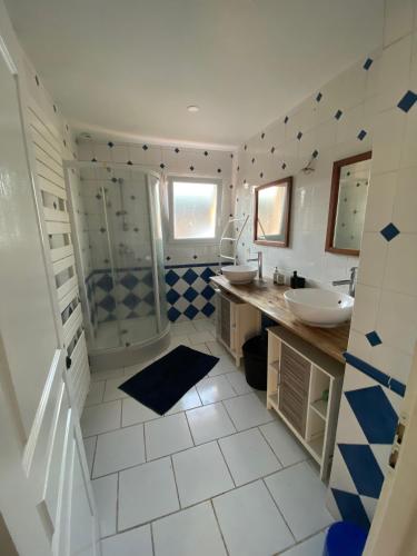a bathroom with a shower and two sinks and a tub at Villa Cazaux in La Teste-de-Buch