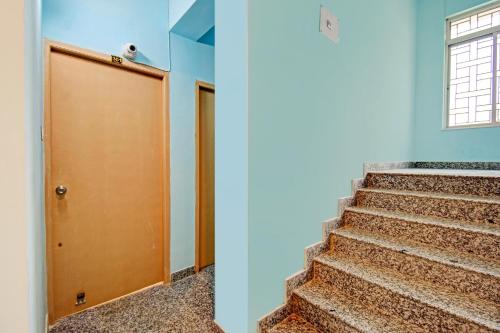 a staircase with a brown door and a window at Hotel O Casa Astra in Salua