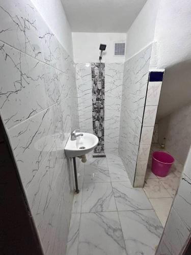a white bathroom with a sink and a shower at Meknès,hameriya in Meknès