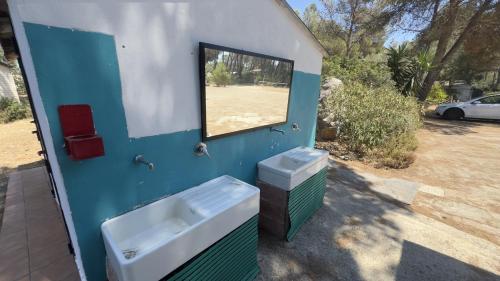 a blue and white bathroom with a sink and a window at Nurral - TENT in Fertilia