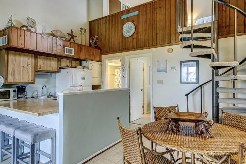 a kitchen with a table and chairs and a staircase at Driftwood Villa - 237 in Edisto Beach