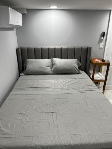 a large bed with a gray headboard in a bedroom at Lg2NY in Westerleigh