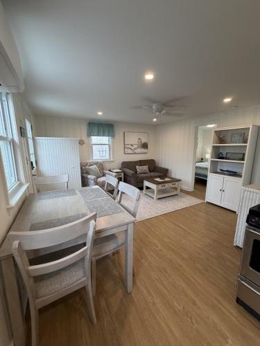 a living room with a table and chairs and a couch at 2 Minute Walk to Beach, Cape Cod Escape in Dennis Port