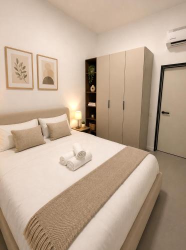 a bedroom with a large bed with a towel on it at סוויטות אקווה איירפורט בוטיק & גרדן - By SEAELO in Eilat