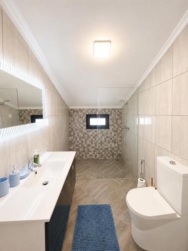 a bathroom with a toilet and a sink and a mirror at Vista Sol in Bicas