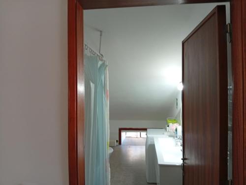 a room with a bathroom with a sink and a door at Aroma das Tílias in Proença-a-Nova