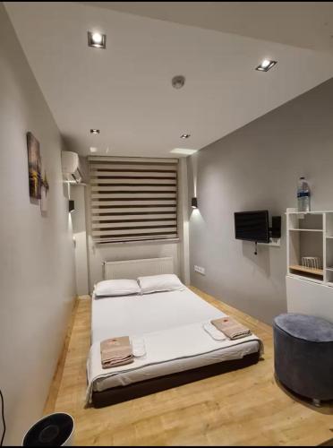 a bedroom with a large white bed and a television at Buhara 93 House - Sultanahmet in Istanbul
