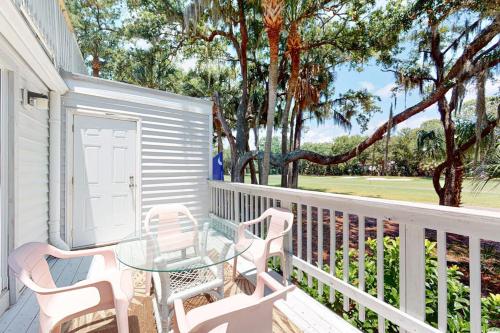 a patio with a glass table and chairs on a porch at Driftwood Villa - 262 in Edisto Beach