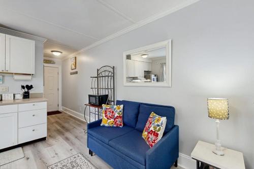 a living room with a blue couch and a kitchen at Sea La Vie in Edisto Island