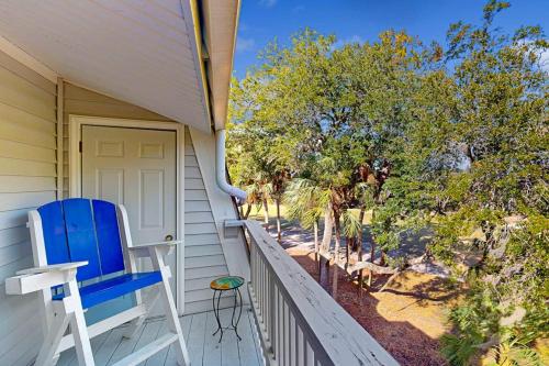 a blue chair sitting on the porch of a house at Driftwood Villa - 267 in Edisto Island