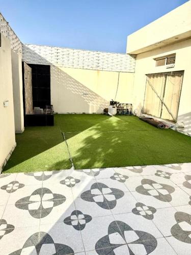 a backyard with a green lawn and a building at شاليهات زارا 3 in Taif