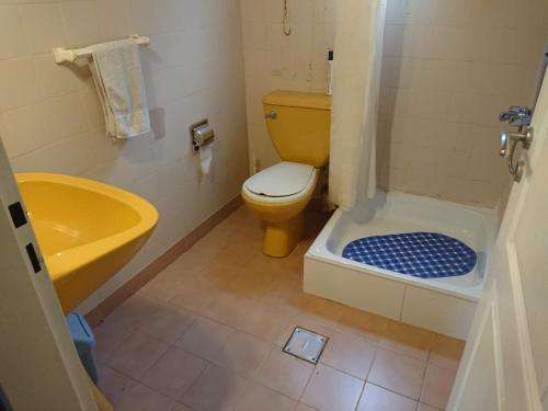 a bathroom with a yellow toilet and a sink at nisueñes in Belén de Escobar