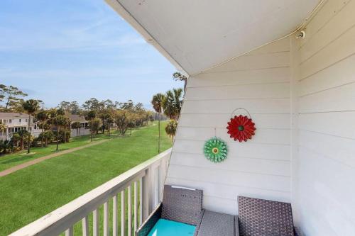 a porch with two chairs and a wreath at Driftwood Villa - 287 in Edisto Beach