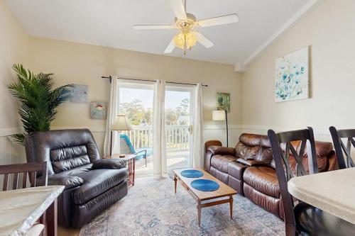 a living room with leather furniture and a ceiling fan at Driftwood Villa - 287 in Edisto Beach