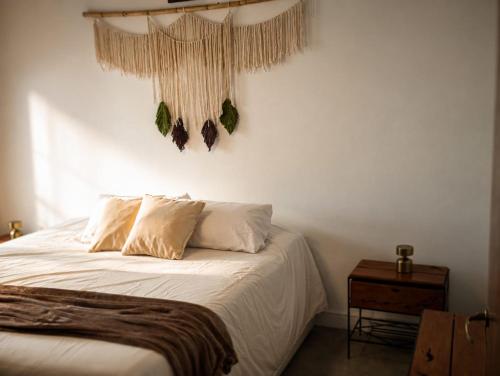 a bedroom with a bed with white sheets and pillows at Quinta La llama violeta in Campana