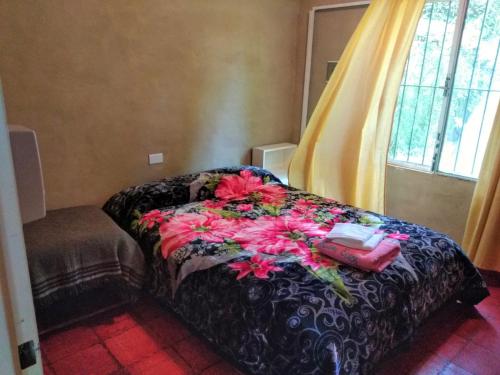 a bed with flowers on it in a room at nisueñes in Belén de Escobar