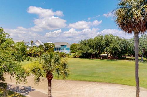 two palm trees in front of a golf course at Driftwood Villa - 259 in Edisto Beach