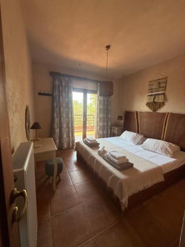 a bedroom with a large bed and a window at Althea Beachside Apartments in Potokáki