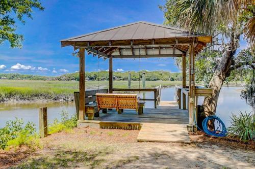 a wooden gazebo with a bench and a table at In Spite of Ourselves in Edisto Beach