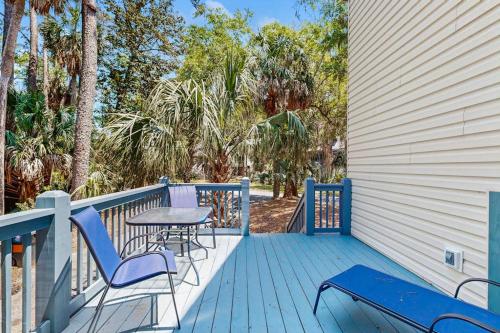 a deck with a table and chairs on a house at Artsea Phartsea in Edisto Beach