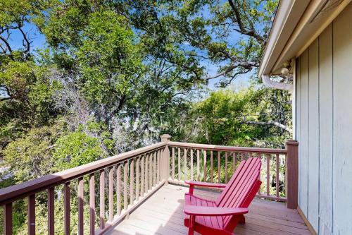 a pair of red chairs sitting on a porch at Cupid's Nest in Edisto Beach