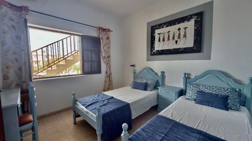 a bedroom with two beds and a window at Mistura Fina in Sal Rei
