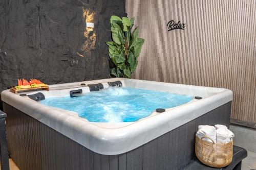 a bath tub filled with blue water in a bathroom at פלואלס - וילת יוקרה עם 4 חדרי שינה ובריכה מחוממת וגקוזי in Shahar