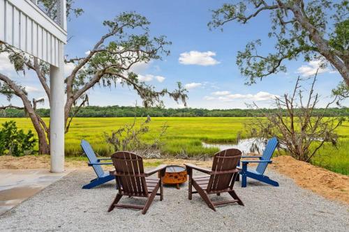 two chairs and a table with a view of a field at Champagne and Sunsets in Edisto Island