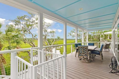 a porch with a table and chairs on it at Champagne and Sunsets in Edisto Island