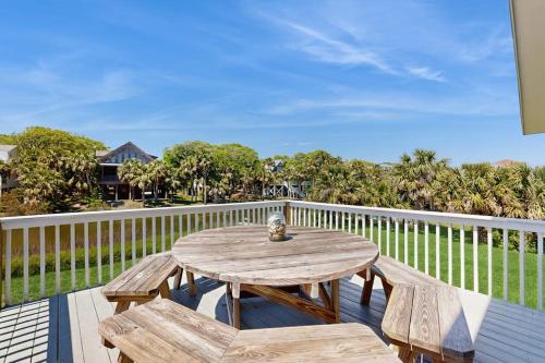 a wooden table and benches on a balcony at Heaven on Harrelson in Edisto Beach