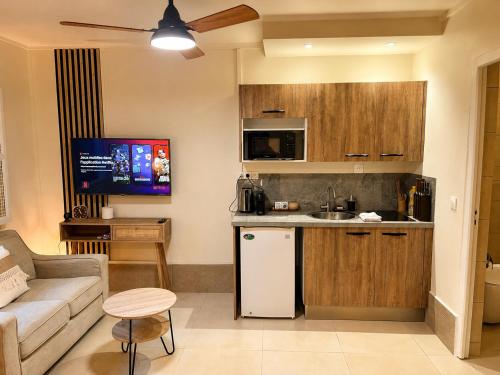 a kitchen and living room with a couch and a table at Studio confort Passamainty in Mamoudzou