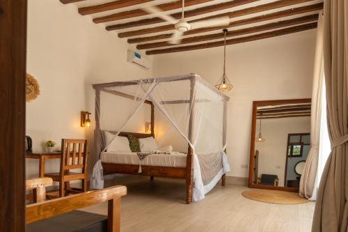 a bedroom with a bed with a canopy at Jaje Paje Villa in Paje