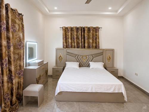 a bedroom with a large white bed and a window at Peace apartment in Brufut
