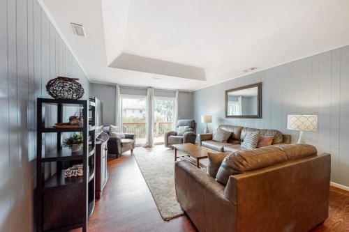 a living room with a brown leather couch and chairs at Hamptons South in Edisto Beach