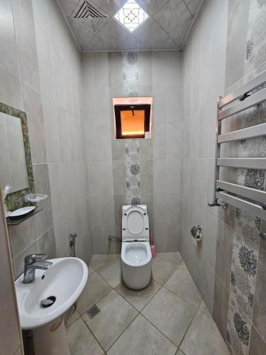 a bathroom with a toilet and a sink and a window at Riverside Villa GDR in Gabala