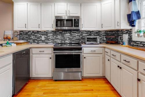 a kitchen with white cabinets and stainless steel appliances at Stare-Gazing in Edisto Beach