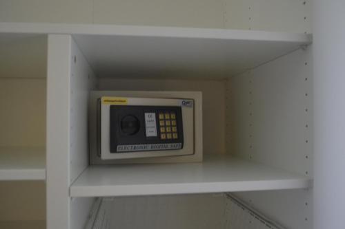 a microwave on a shelf in a room at Baan Andaman Sea Surf in Patong Beach