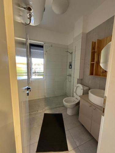 a bathroom with a toilet and a sink at River apartment in Tushemisht
