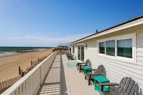 a beach house with chairs and a deck with the beach at Corrigan in Edisto Beach