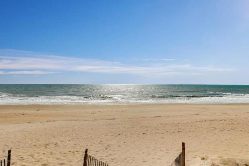 a beach with a fence and the ocean at Corrigan in Edisto Beach