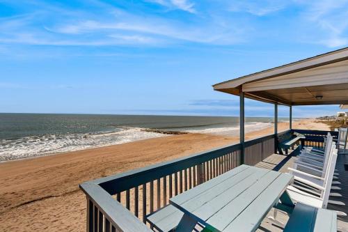 a deck with a table and chairs on the beach at Sunrise, Sunset in Edisto Beach