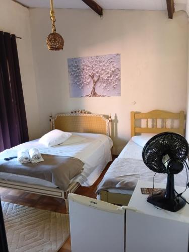 two beds in a room with a box at Chalé Pingo de Ouro Socorro SP in Socorro