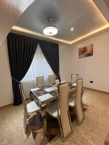 a dining room with a table and chairs and a window at Dreamland prestige Homes in Sasabi